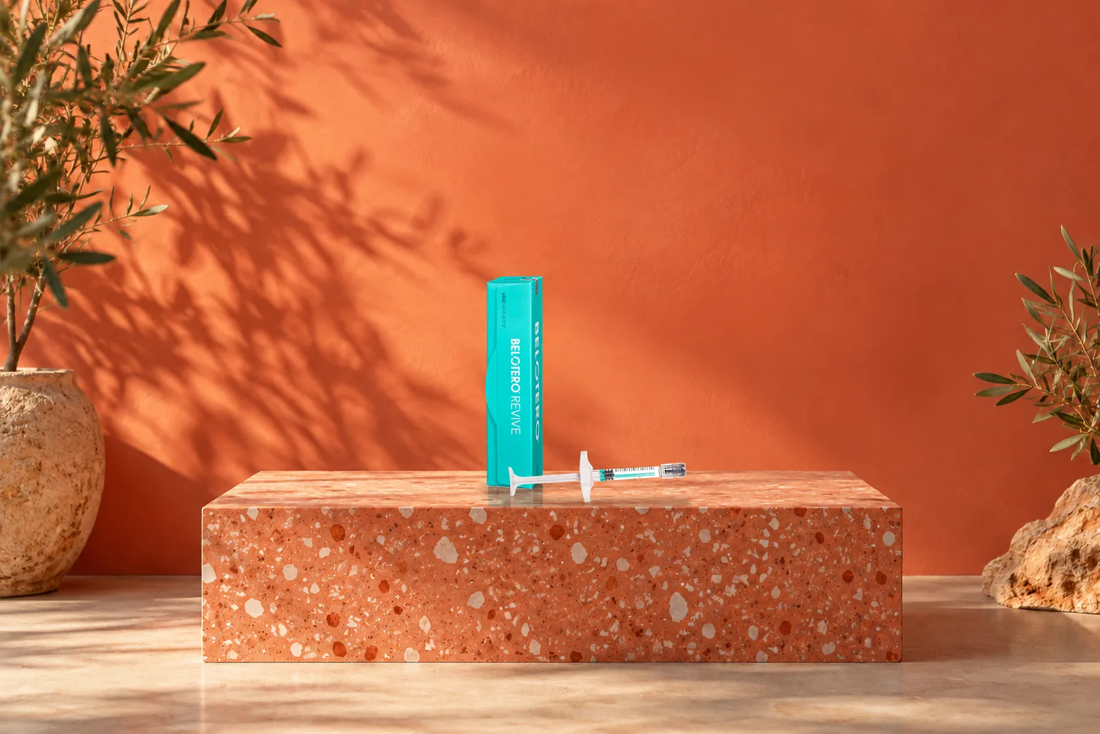 Caja y jeringa de Revive sobre una base de terrazo